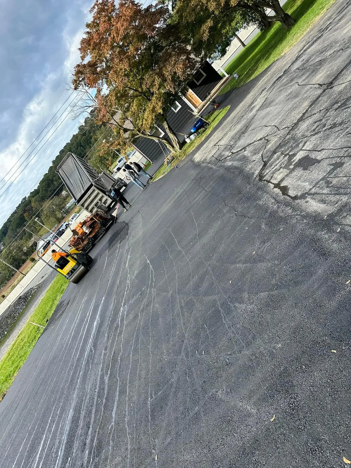 Driveway Pros crew laying hot asphalt with a paver
